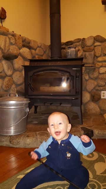 a boy sitting in front of a stove